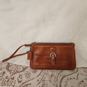 Stylish Coach brown leather wristlet with front pocket and silver metal clasps